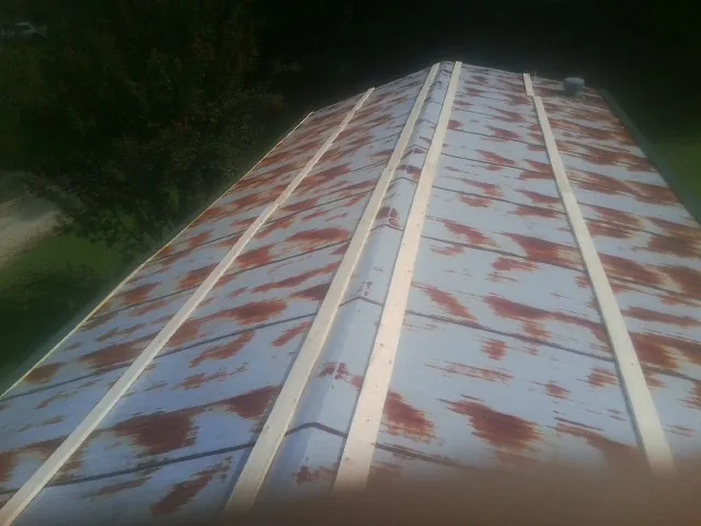 Rusted metal roof panels with new wood purlins before replacement — Storm Damage Roof Repair in Santa by Roofing Brothers