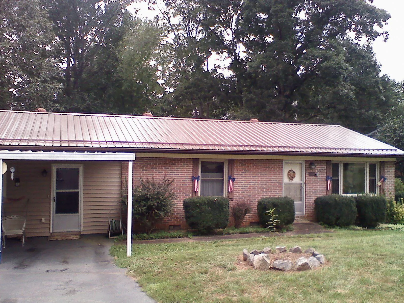 Bronze metal roof and carport on a brick ranch home — Roof Repair work by our crew in Santa